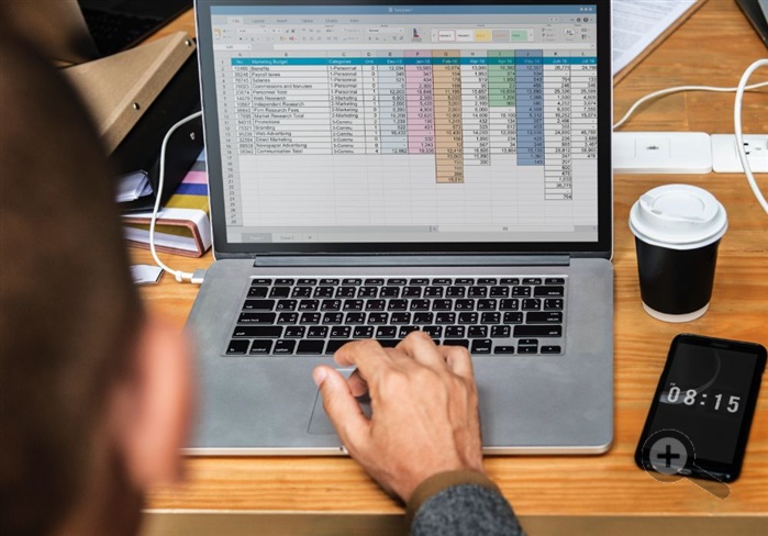 notebook-Excel-muz-telefon-kava-klavesnice-vypocty-kalkulace-dreveny-stůl